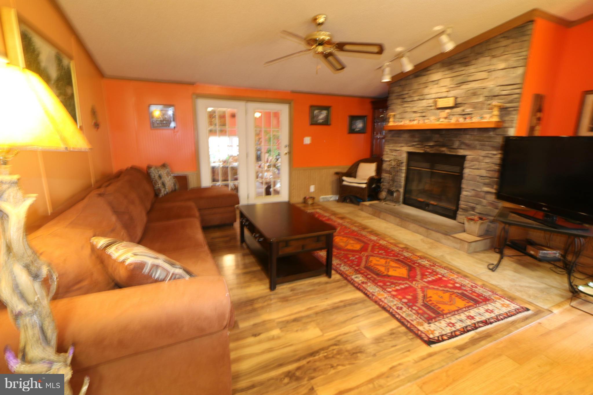 24709 Raven Rock Road Smithsburg, MD 21783 - Photo 8 of 20 a living room with furniture a flat screen tv and a fireplace