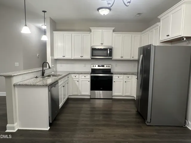 a kitchen with white cabinets and stainless steel appliances