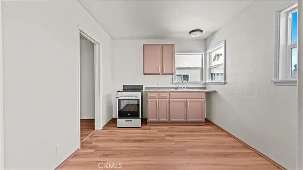 a view of a kitchen with wooden floor and electronic appliances