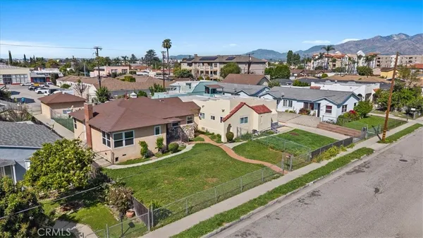 an aerial view of residential houses with outdoor space and street view
