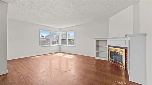 an empty room with windows and fireplace