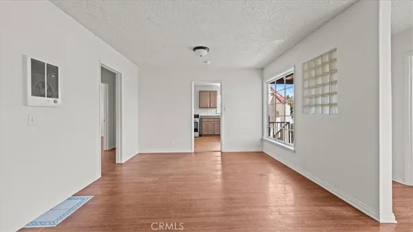a view of an empty room with window and wooden floor