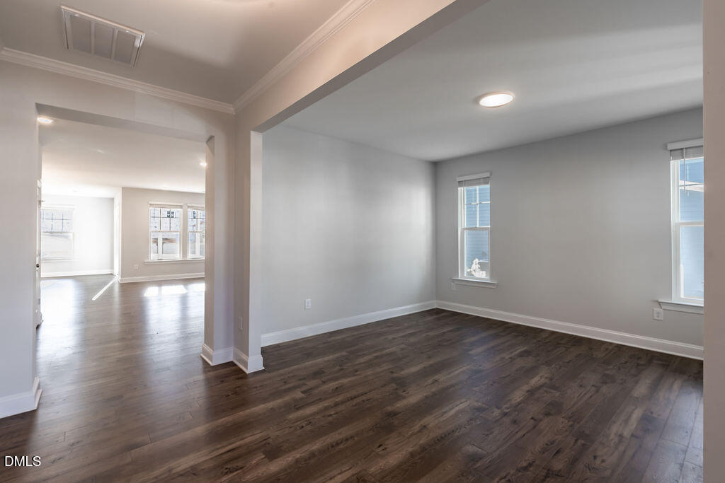 717 Ressler Street Holly Springs, NC 27540 - Photo 11 of 32 a view of an empty room with wooden floor and a window