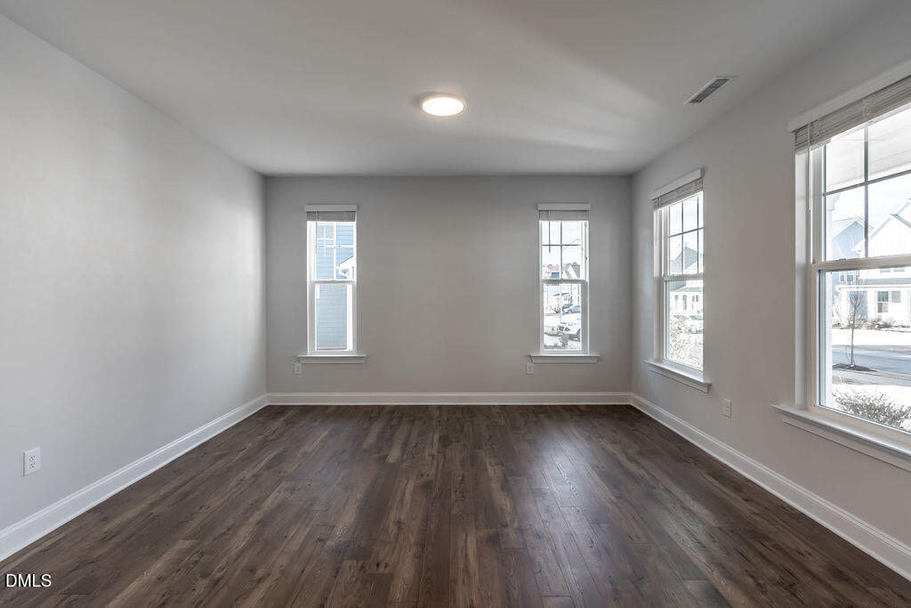 717 Ressler Street Holly Springs, NC 27540 - Photo 12 of 32 an empty room with wooden floor and windows