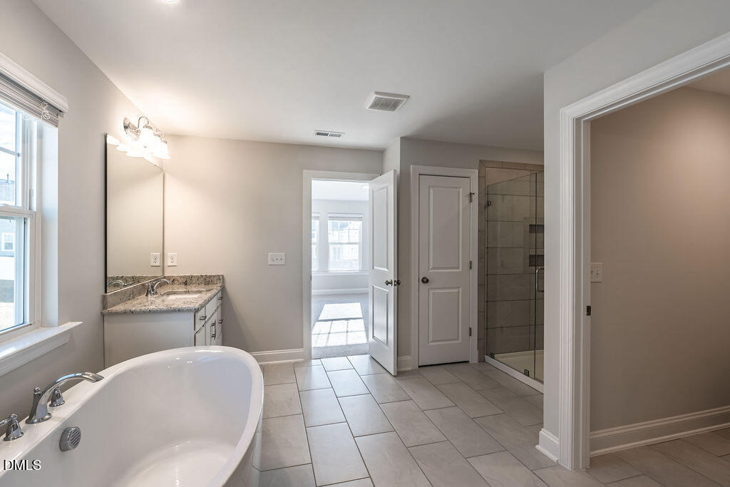 717 Ressler Street Holly Springs, NC 27540 - Photo 19 of 32 a spacious bathroom with a sink and a mirror
