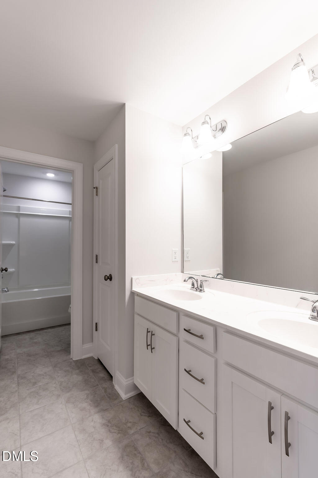 717 Ressler Street Holly Springs, NC 27540 - Photo 22 of 32 a bathroom with a double vanity sink a large mirror and a bathtub
