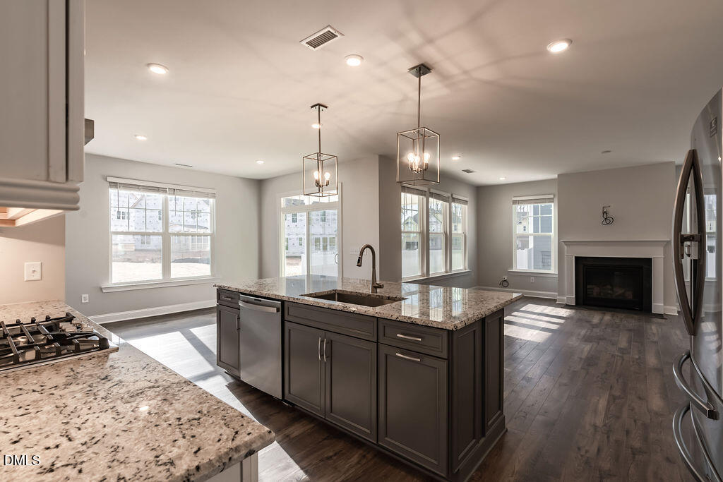 717 Ressler Street Holly Springs, NC 27540 - Photo 4 of 32 a kitchen with granite countertop a stove oven and a sink