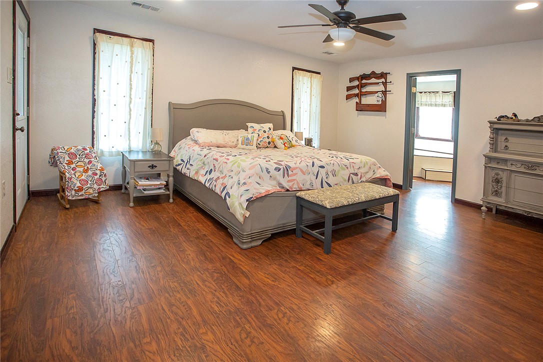 3726 St Joe Road Atkins, AR 72823 - Photo 12 of 41 Spacious room featuring wood-finish flooring, two windows, and a ceiling fan with integrated lighting