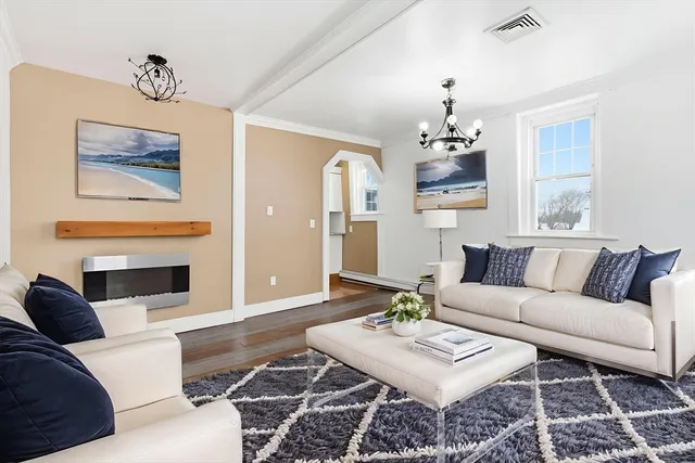 a living room with furniture a fireplace and a chandelier