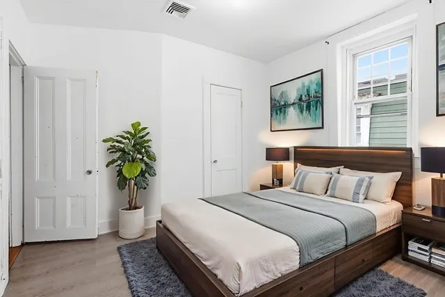 a bedroom with bed and a potted plant