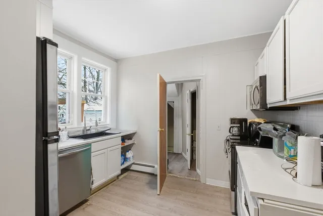 a kitchen with stainless steel appliances granite countertop a sink and cabinets with wooden floor