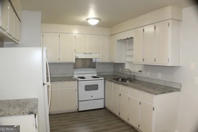 a kitchen with a sink stove and refrigerator