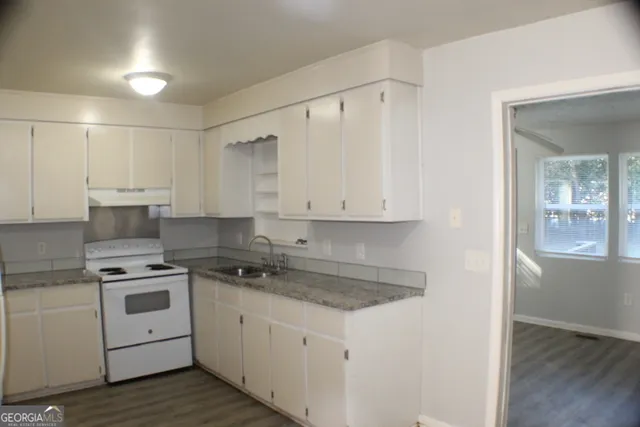a kitchen with white cabinets stainless steel appliances and sink