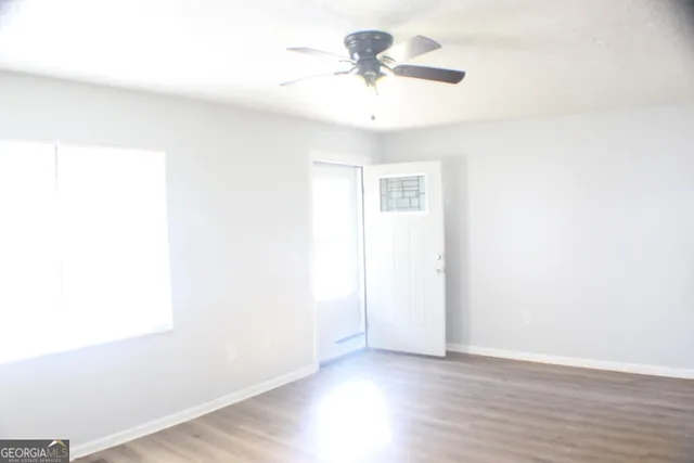 a view of an empty room with wooden floor