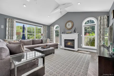 a living room with furniture a clock and a fireplace