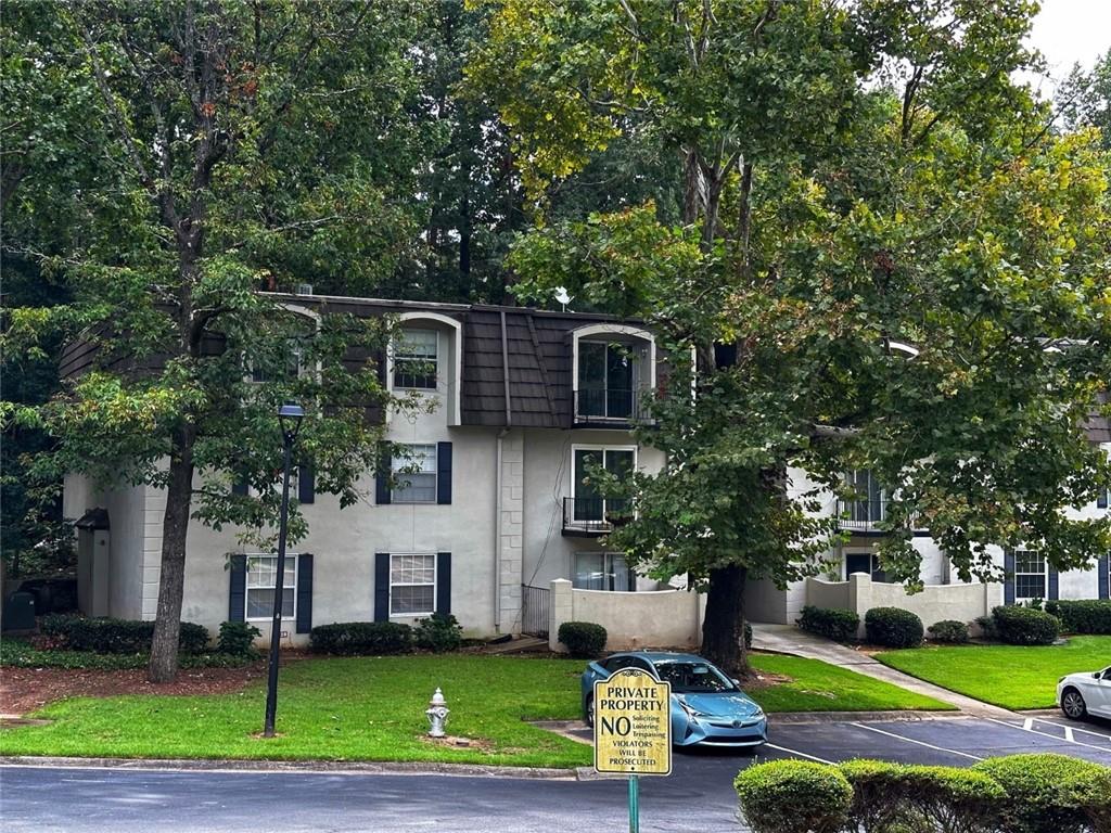 725 Dalrymple Road, Unit 3E Atlanta, GA 30328 - Photo 1 of 1 a front view of a house with a yard and trees