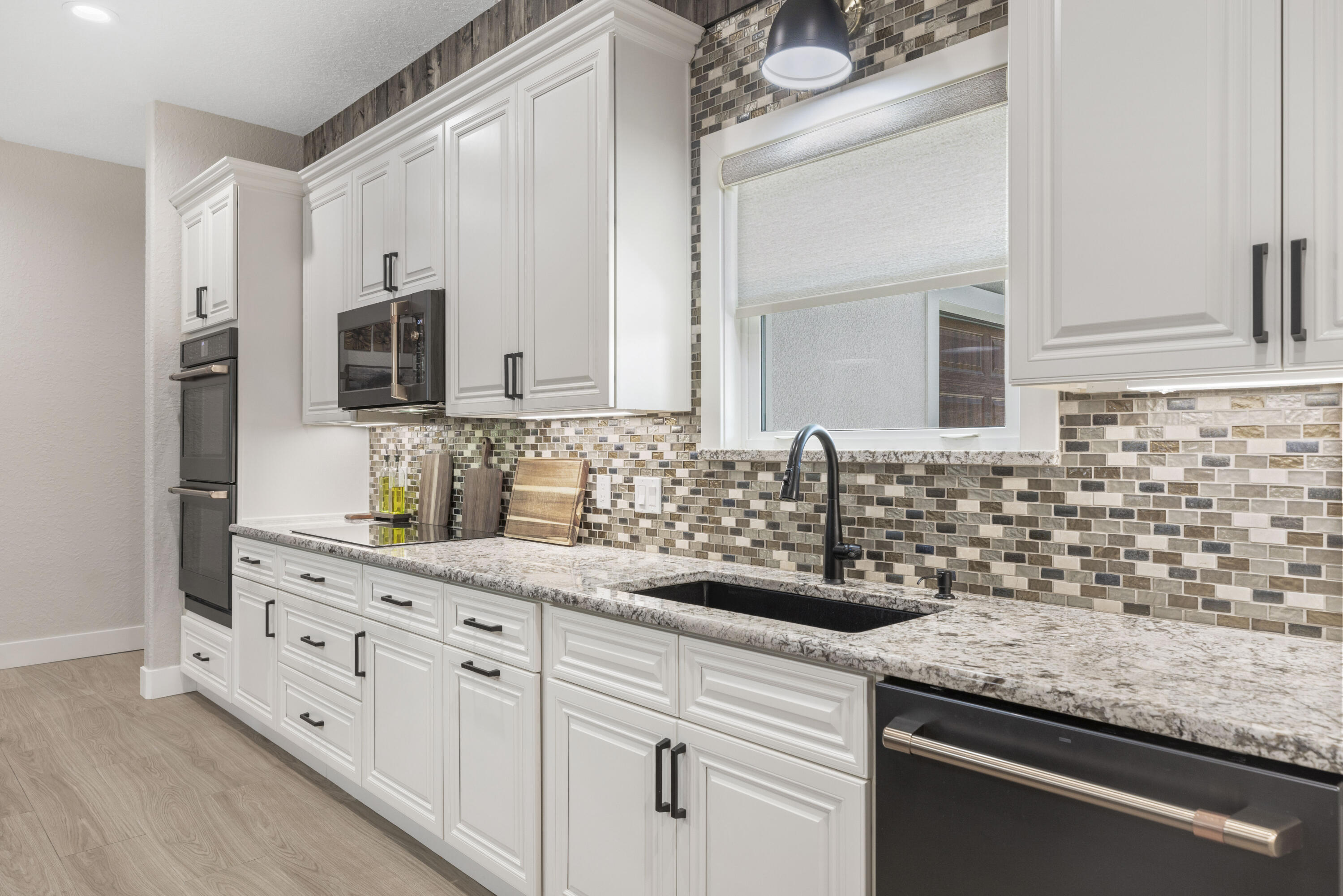 4544 Celestial Drive Grant Valkaria, FL 32949 - Photo 14 of 73 a kitchen with granite countertop white cabinets and stainless steel appliances