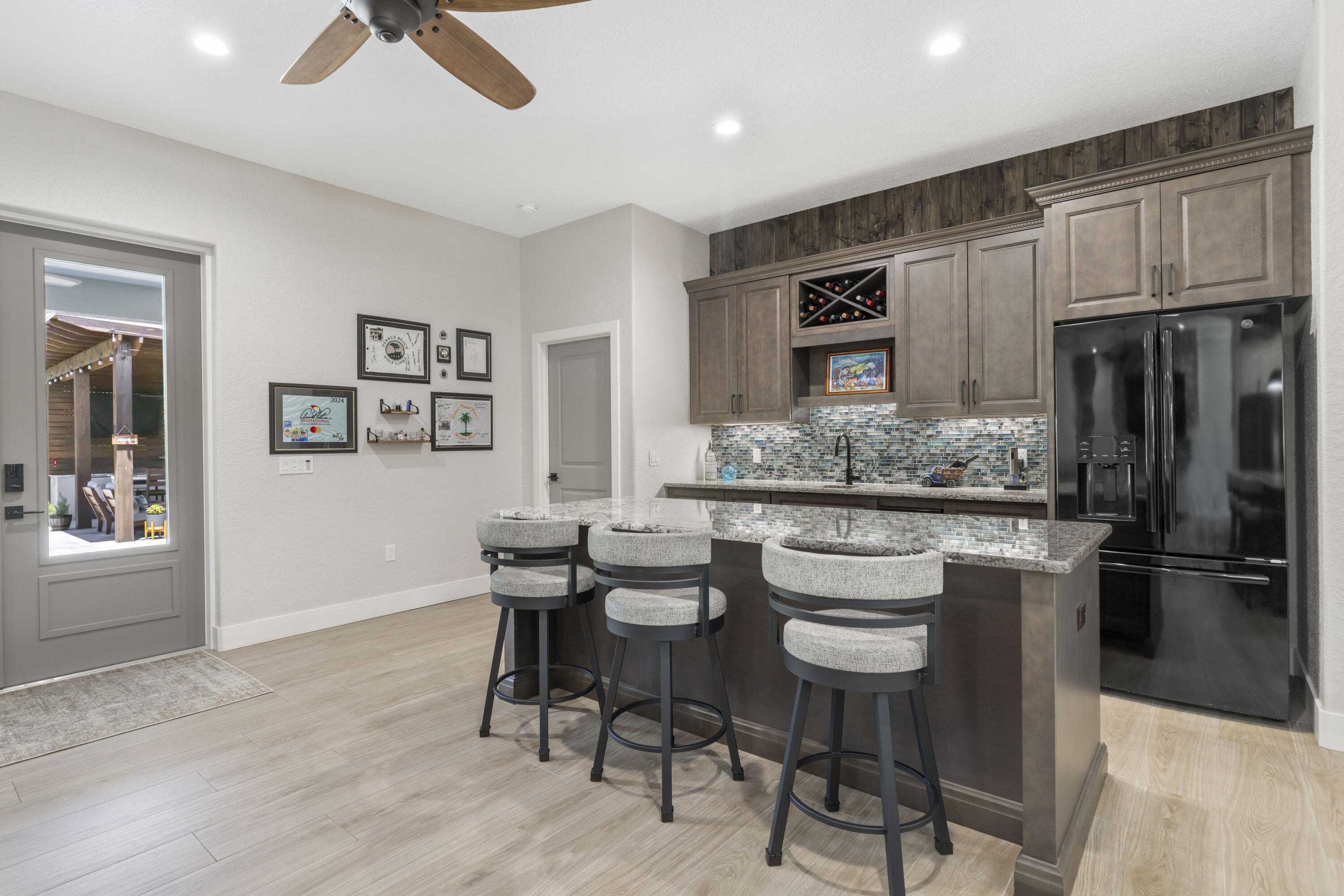 4544 Celestial Drive Grant Valkaria, FL 32949 - Photo 20 of 73 a kitchen with stainless steel appliances kitchen island granite countertop a kitchen island and chairs in it