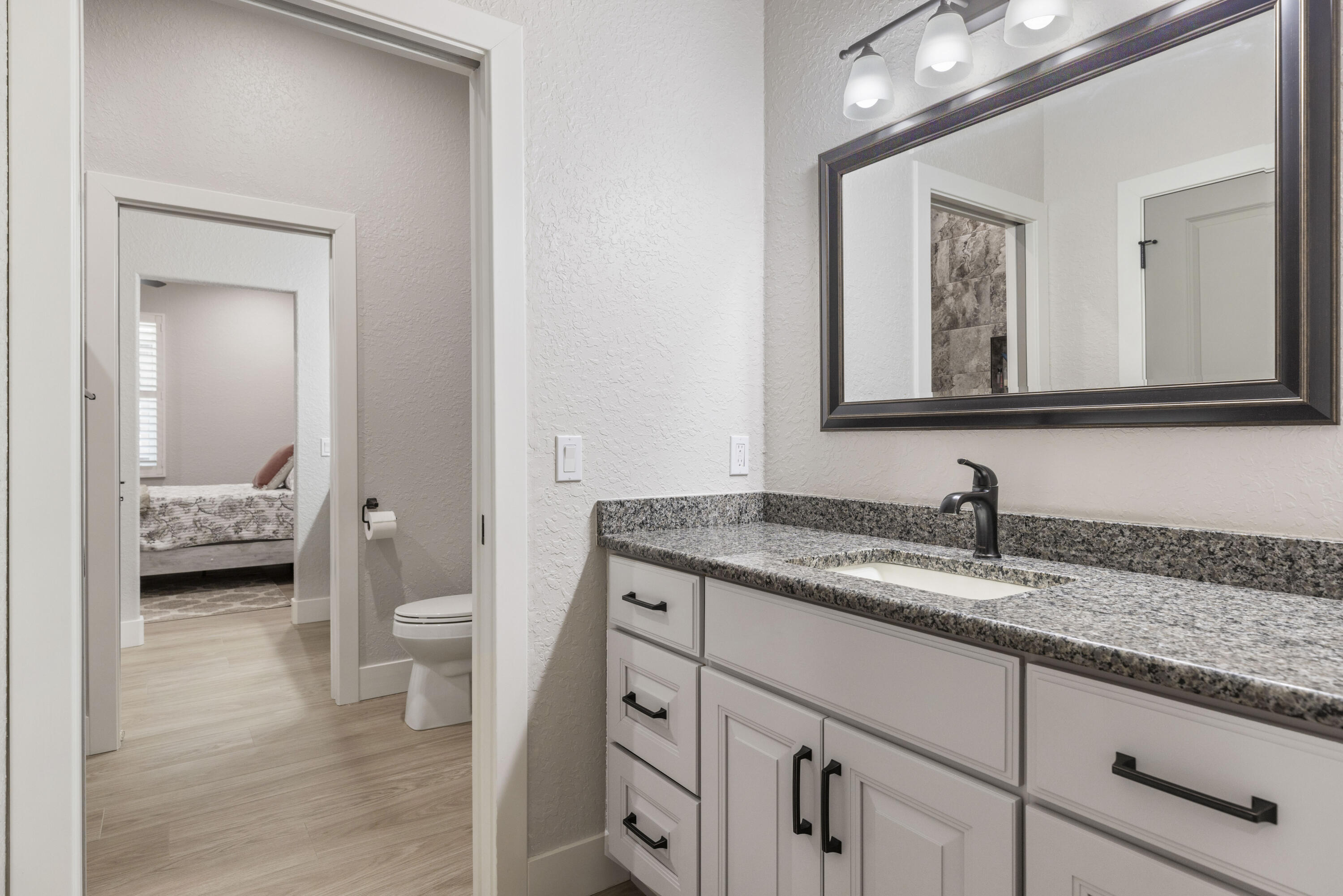 4544 Celestial Drive Grant Valkaria, FL 32949 - Photo 48 of 73 a en suite bathroom with a granite countertop sink and a mirror