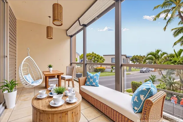 a living room with patio furniture and a potted plant