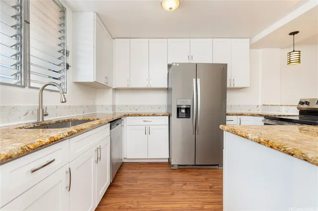 a kitchen with granite countertop a refrigerator and a sink