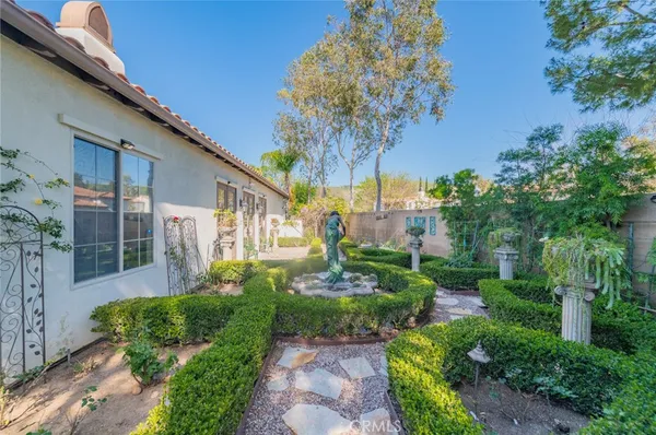 a view of a house with a yard and potted plants