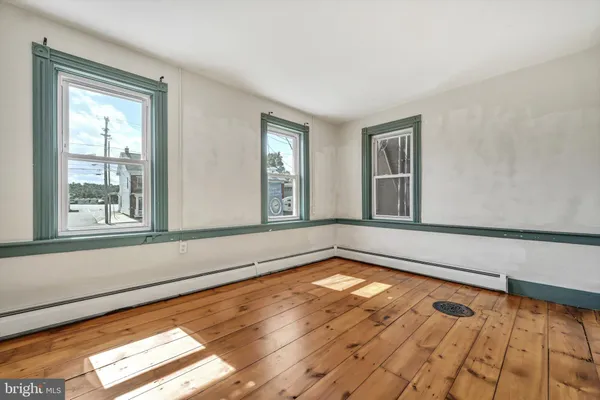 a view of empty room with wooden floor