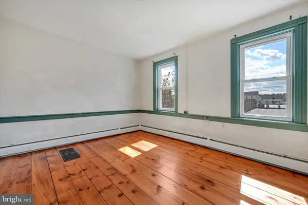 a view of empty room with wooden floor