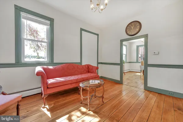 a view of a workspace room with wooden floor and furniture