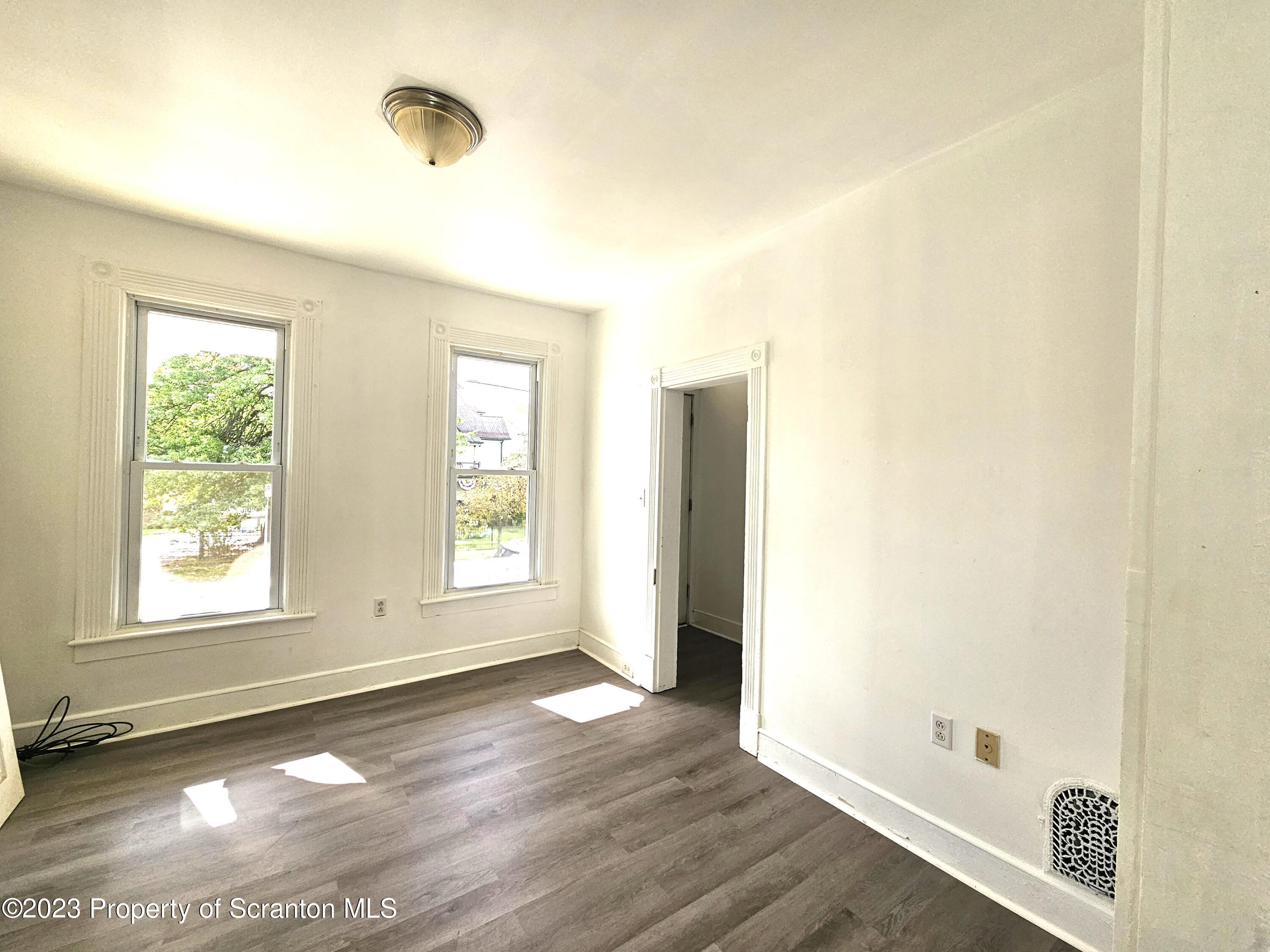 907 Green Ridge Street Scranton, PA 18509 - Photo 3 of 12 a view of an empty room with a window and wooden floor