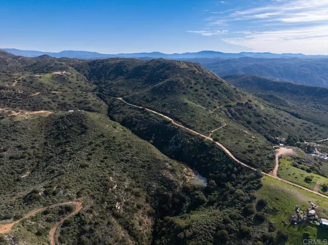 a view of a large mountains with green field