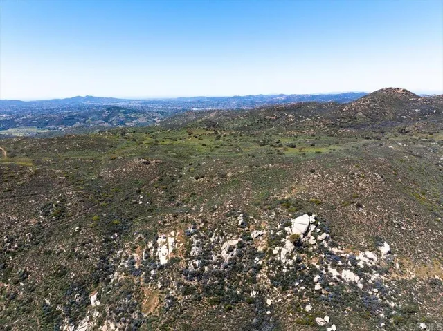 a view of a big yard with mountain and trees