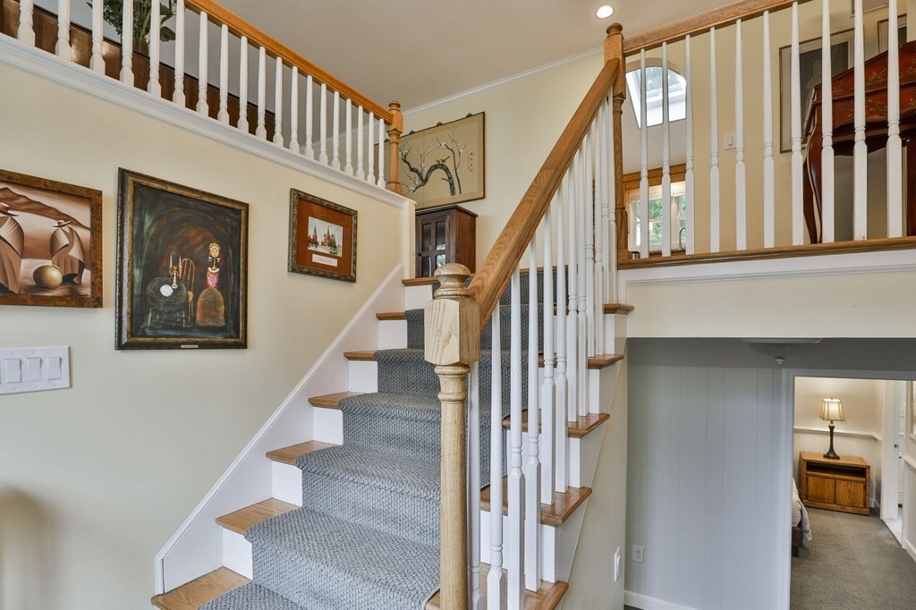 75 Valley Road Milton, MA 02186 - Photo 25 of 41 a view of staircase with lots of frames on wall and a window