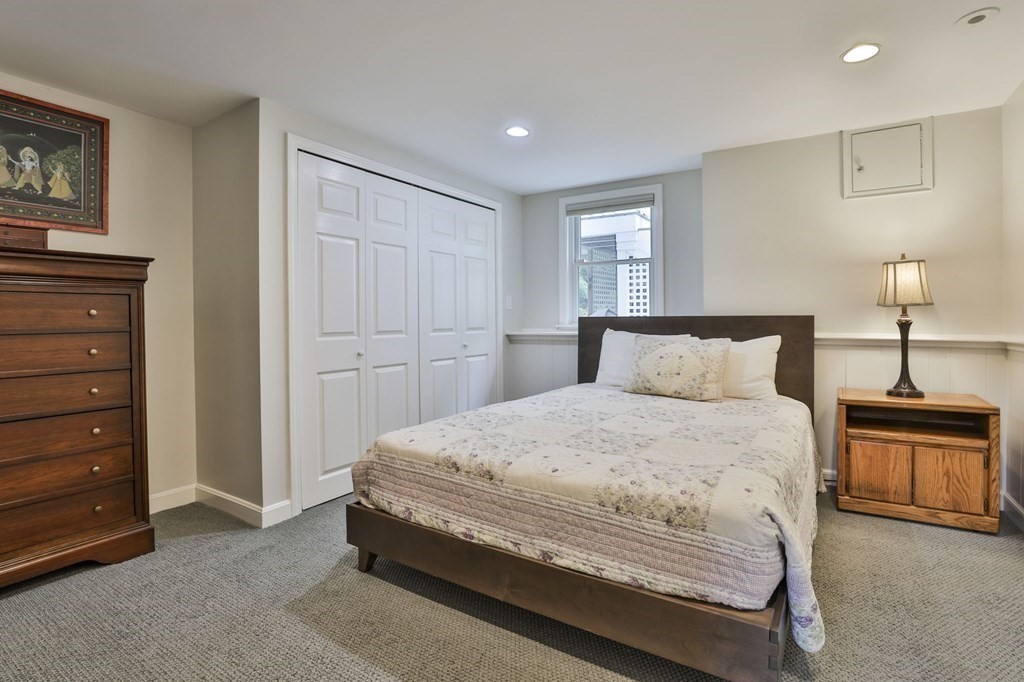 75 Valley Road Milton, MA 02186 - Photo 28 of 41 a bedroom with a bed and a lamp