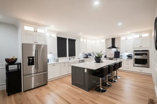 a large kitchen with kitchen island granite countertop a sink and cabinets