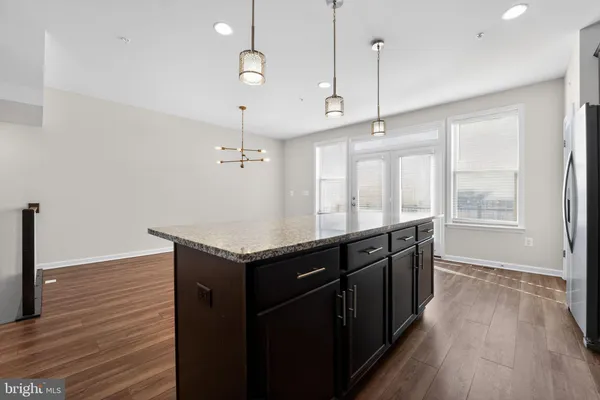 a kitchen with granite countertop a stove and wooden floor
