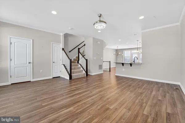 a view of empty room with wooden floor and stairs