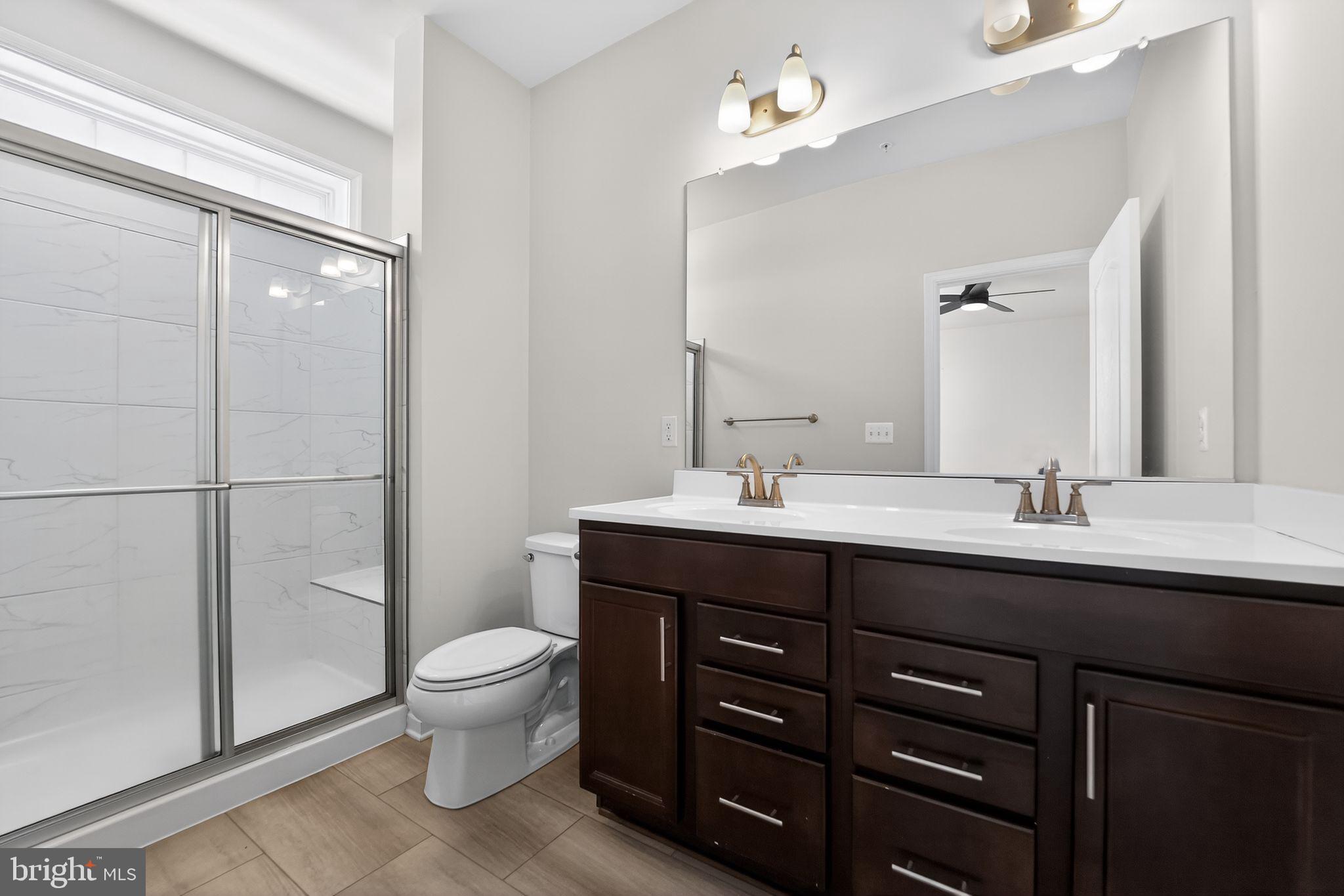 304 Faversham Place Frederick, MD 21701 - Photo 24 of 32 a bathroom with a double vanity sink toilet and a mirror