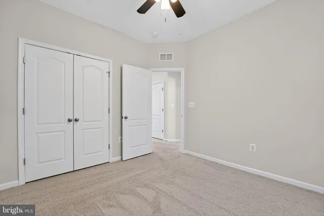 an empty room with chandelier fan