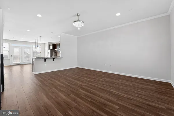 a view of empty room with wooden floor and window