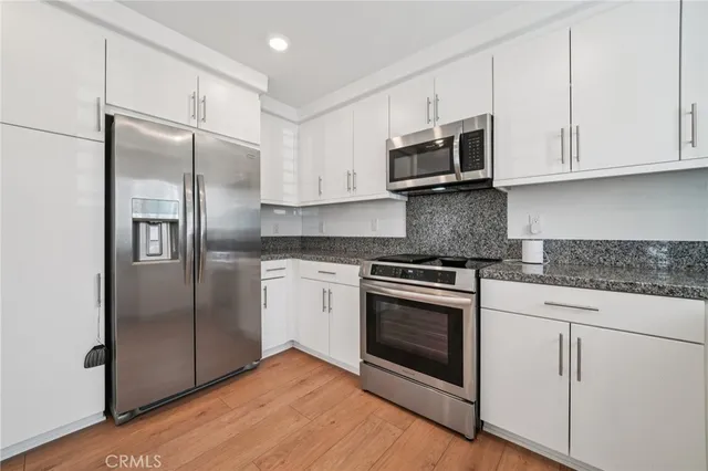a kitchen with stainless steel appliances granite countertop a refrigerator sink and microwave