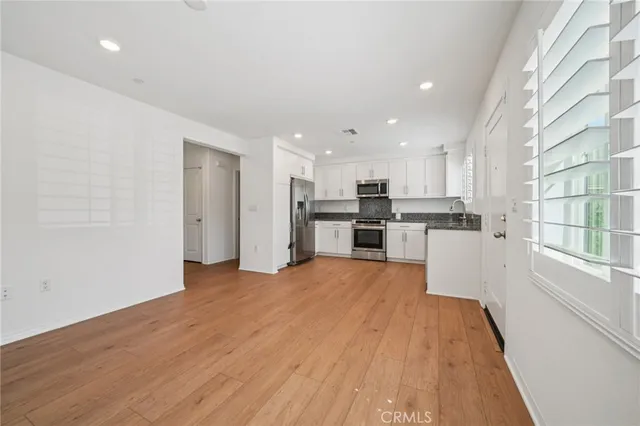 a view of kitchen with wooden floor and electronic appliances