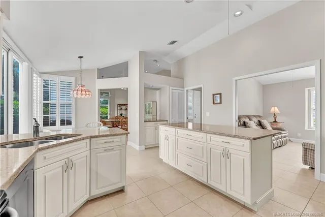 a kitchen with white cabinets and sink