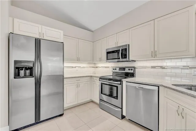 a kitchen with cabinets stainless steel appliances and a counter space