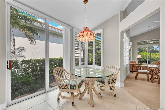 a dining room with furniture large windows and a chandelier