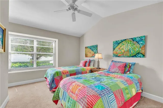 a bedroom with a bed a window and painting on the wall