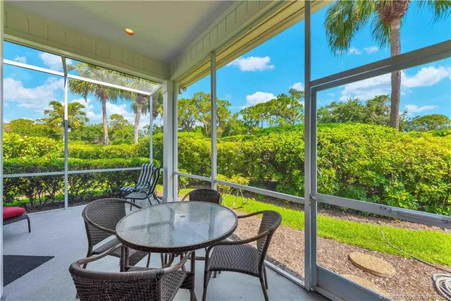a view of a porch with furniture and a yard