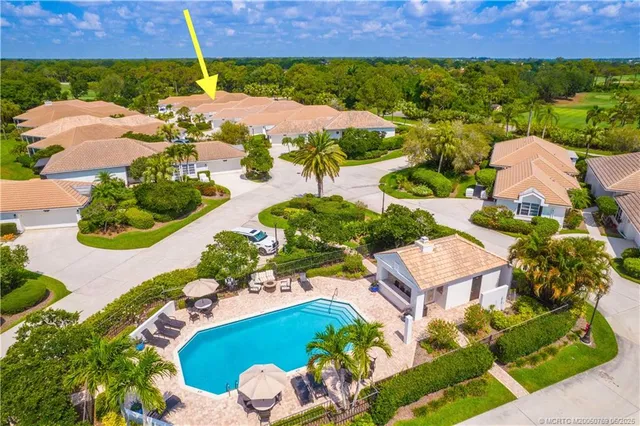 an aerial view of a house with a garden and lake view
