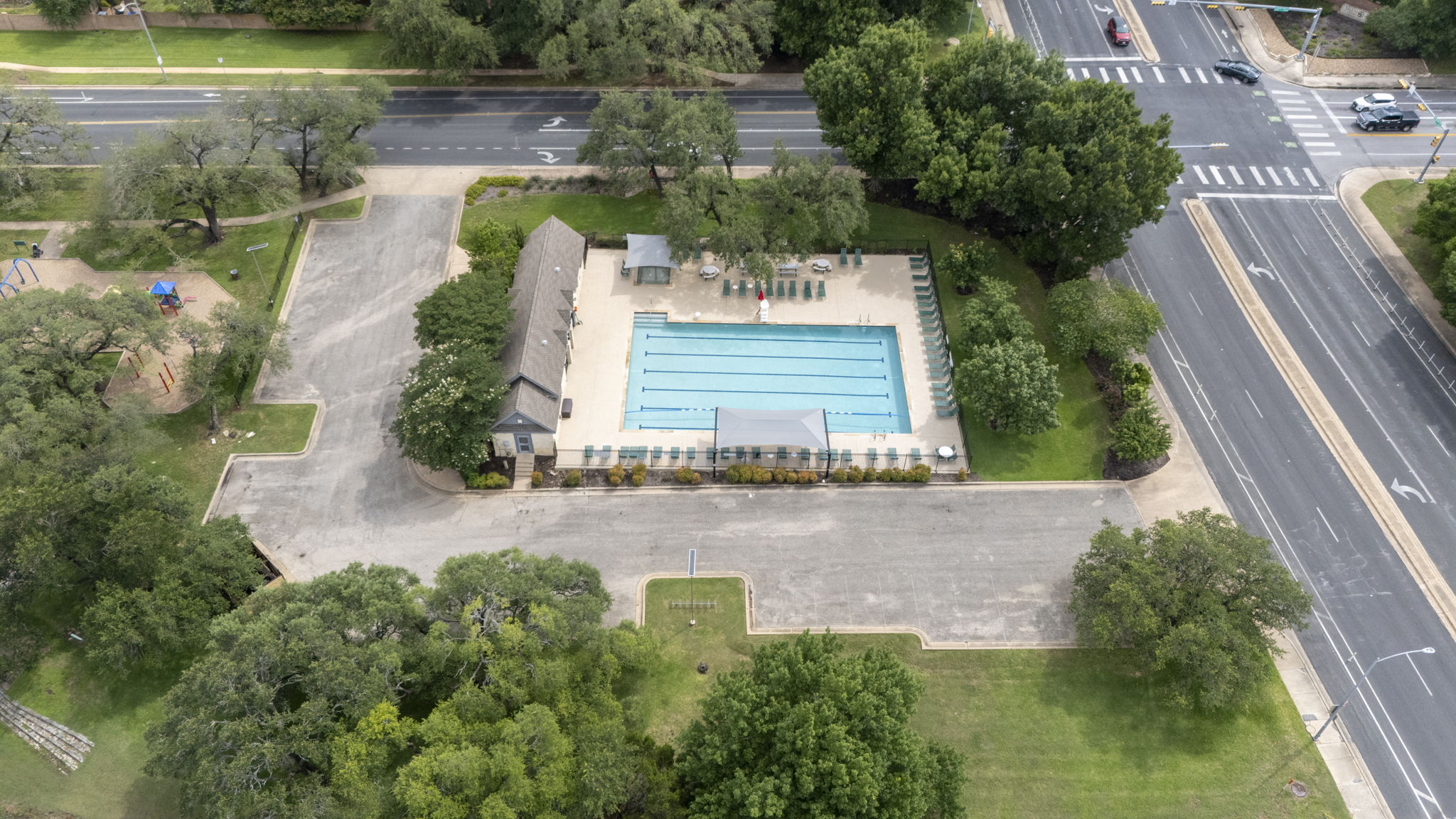 7172 Ridge Oak Road Austin, TX 78749 - Photo 39 of 40 An aerial perspective showcases the community pool, surrounded by mature trees and adjacent to a thoroughfare.