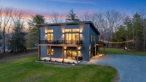 a view of a house with a yard and sitting area